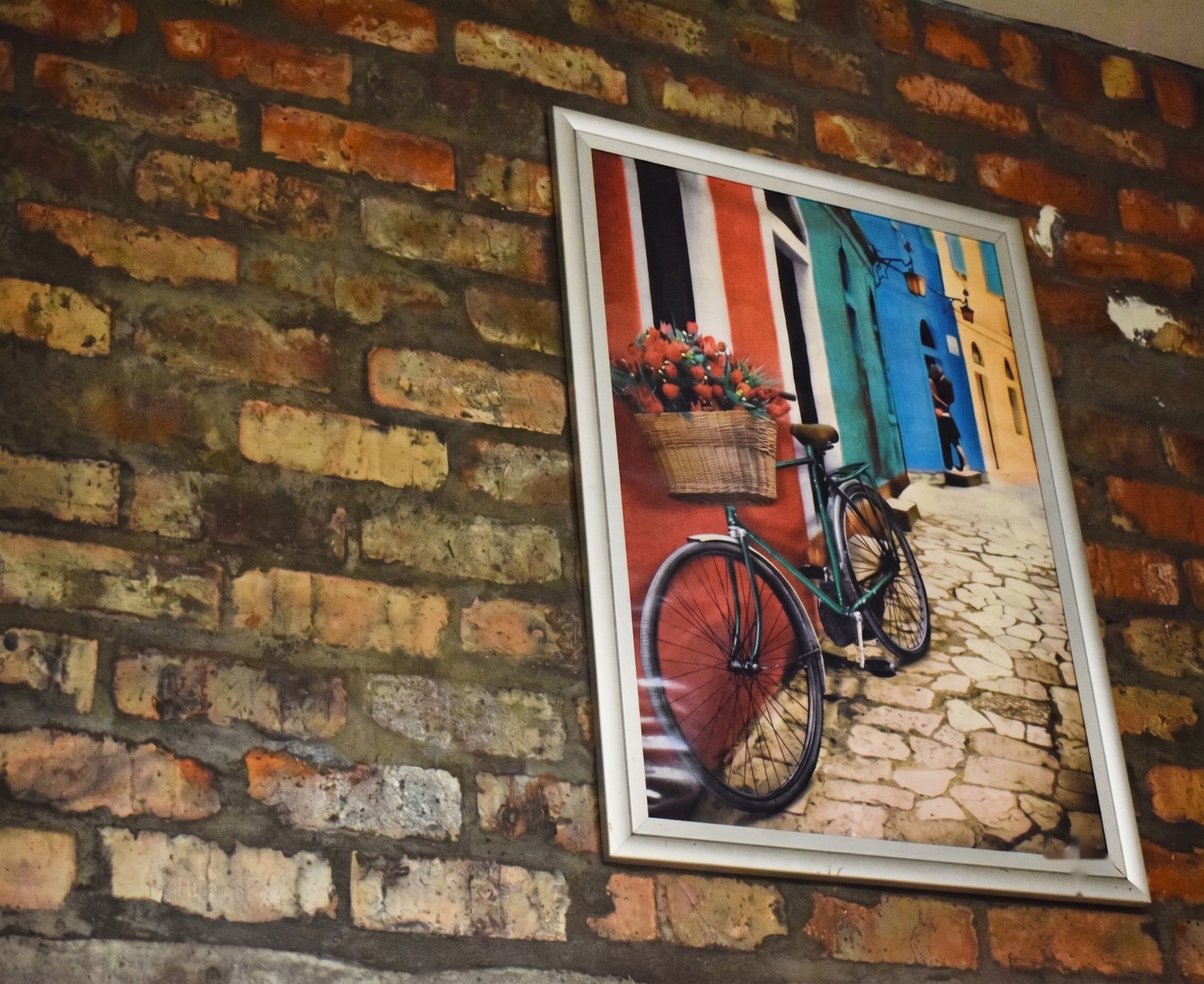 Framed Italian street art on Italforno's exposed brick wall